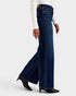 Person wearing dark blue wide-leg jeans on a white background