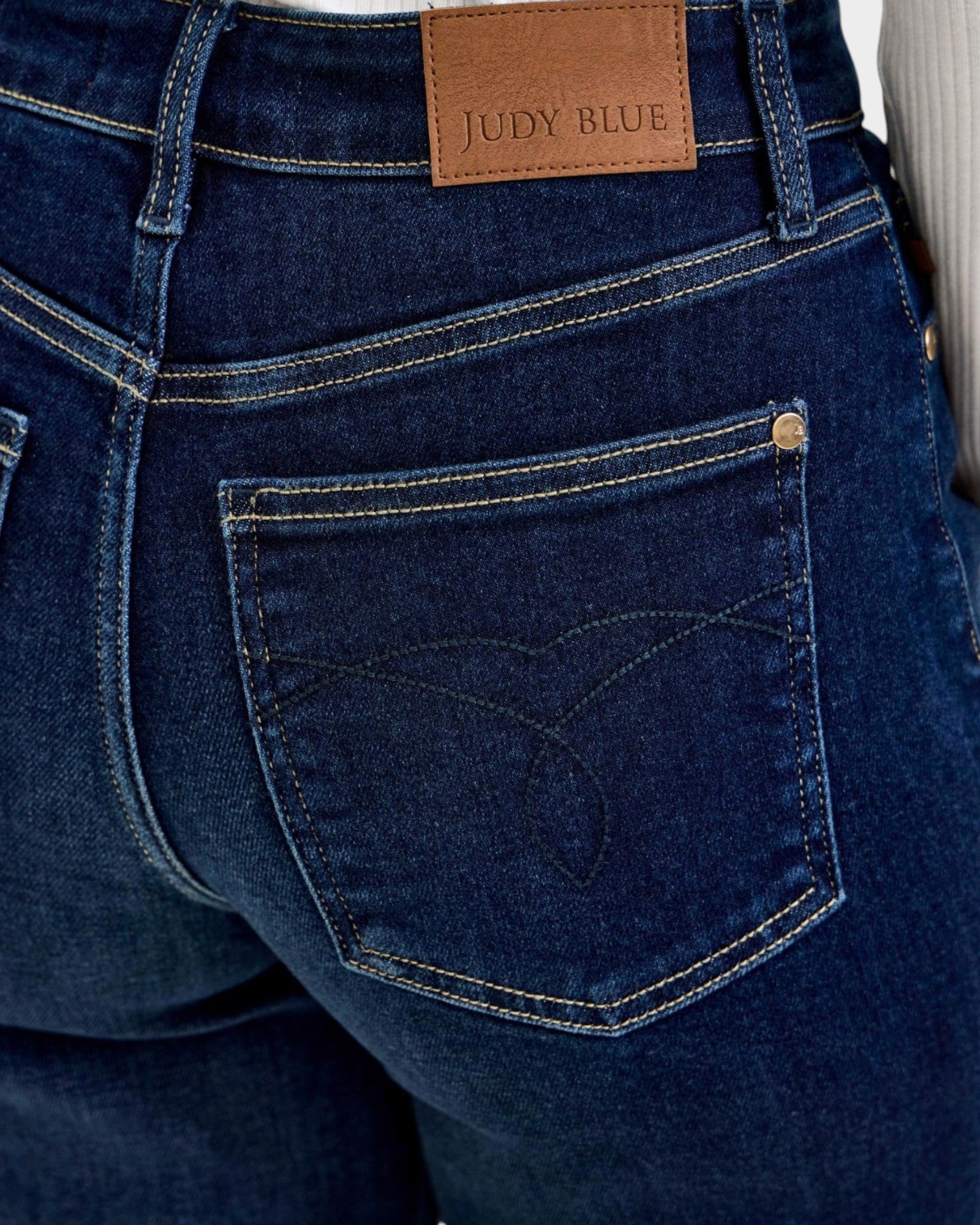 Close-up of blue jeans with a Judy Blue label on the back pocket.