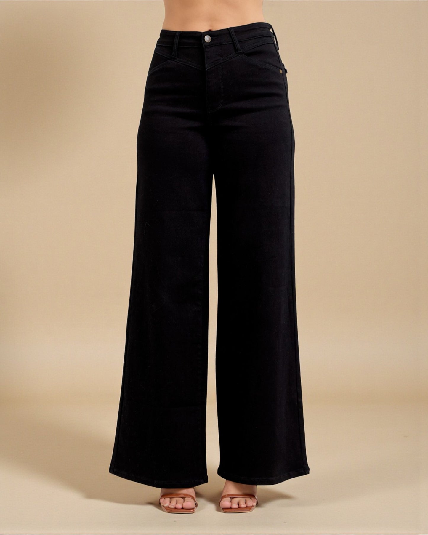 Black wide-leg jeans on a beige background