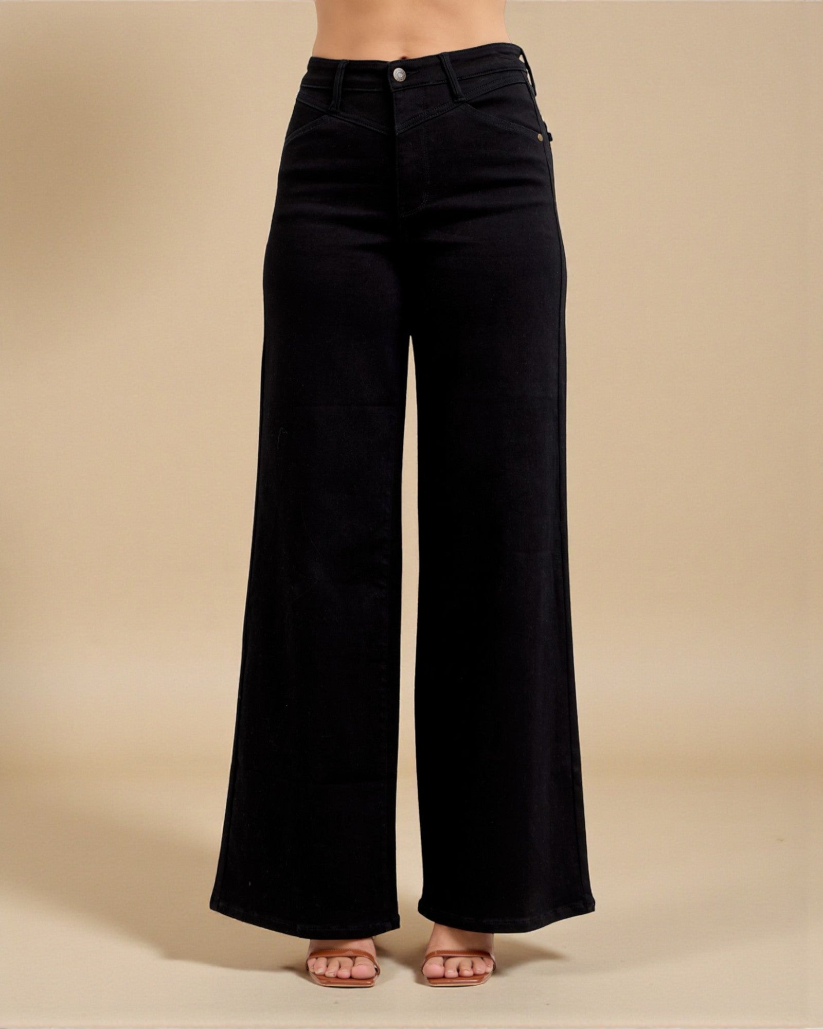 Black wide-leg jeans on a beige background