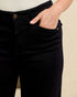 Person wearing black pants with a beige background