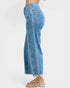 Blue acid-wash jeans worn by a person on a white background