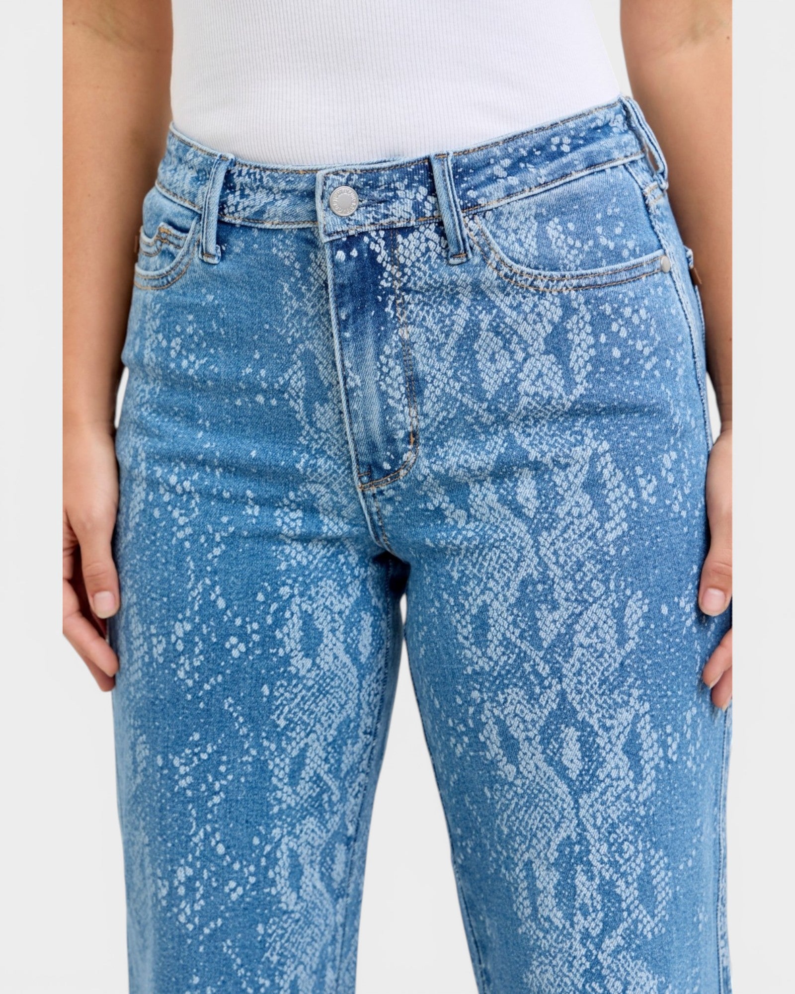 Blue acid-wash jeans worn by a person on a white background