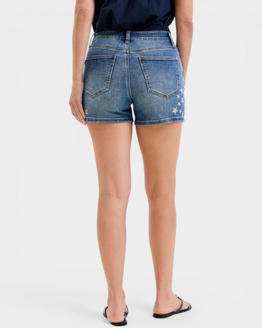 Person wearing blue denim shorts on a white background
