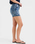 Denim shorts with star pattern worn by a person on a white background