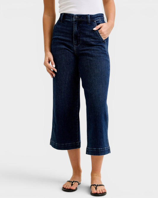Person wearing dark blue jeans on a white background
