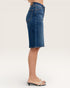 Blue denim skirt worn by a person on a white background