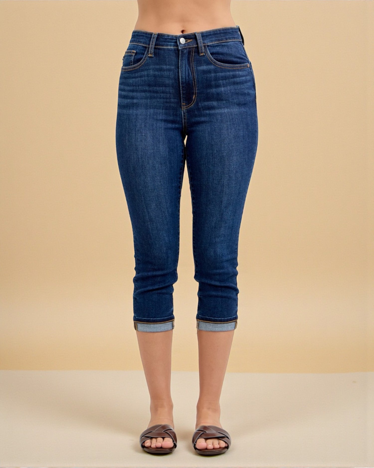 Blue jeans worn by a person on a beige background