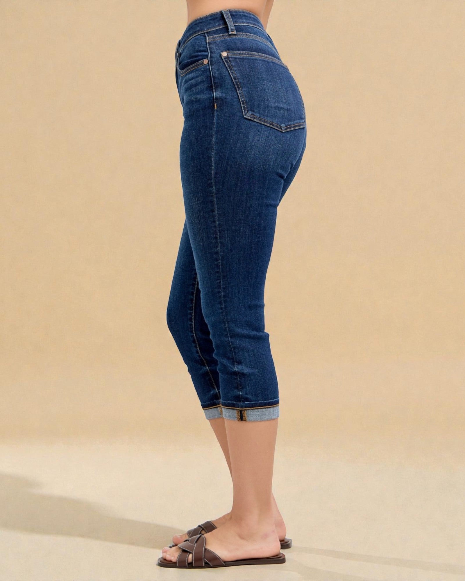 Blue jeans worn by a person on a beige background