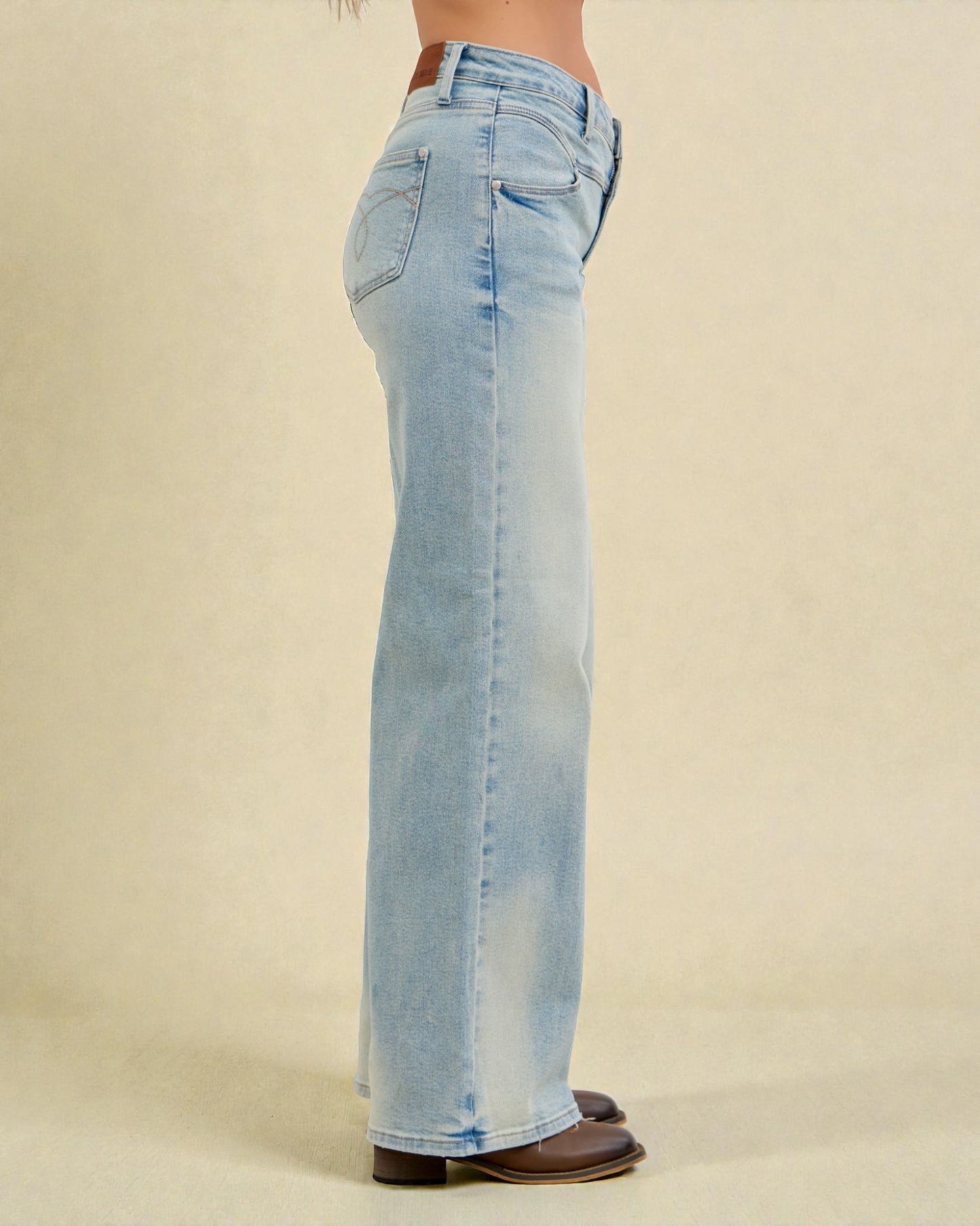Light blue jeans worn by a person on a beige background