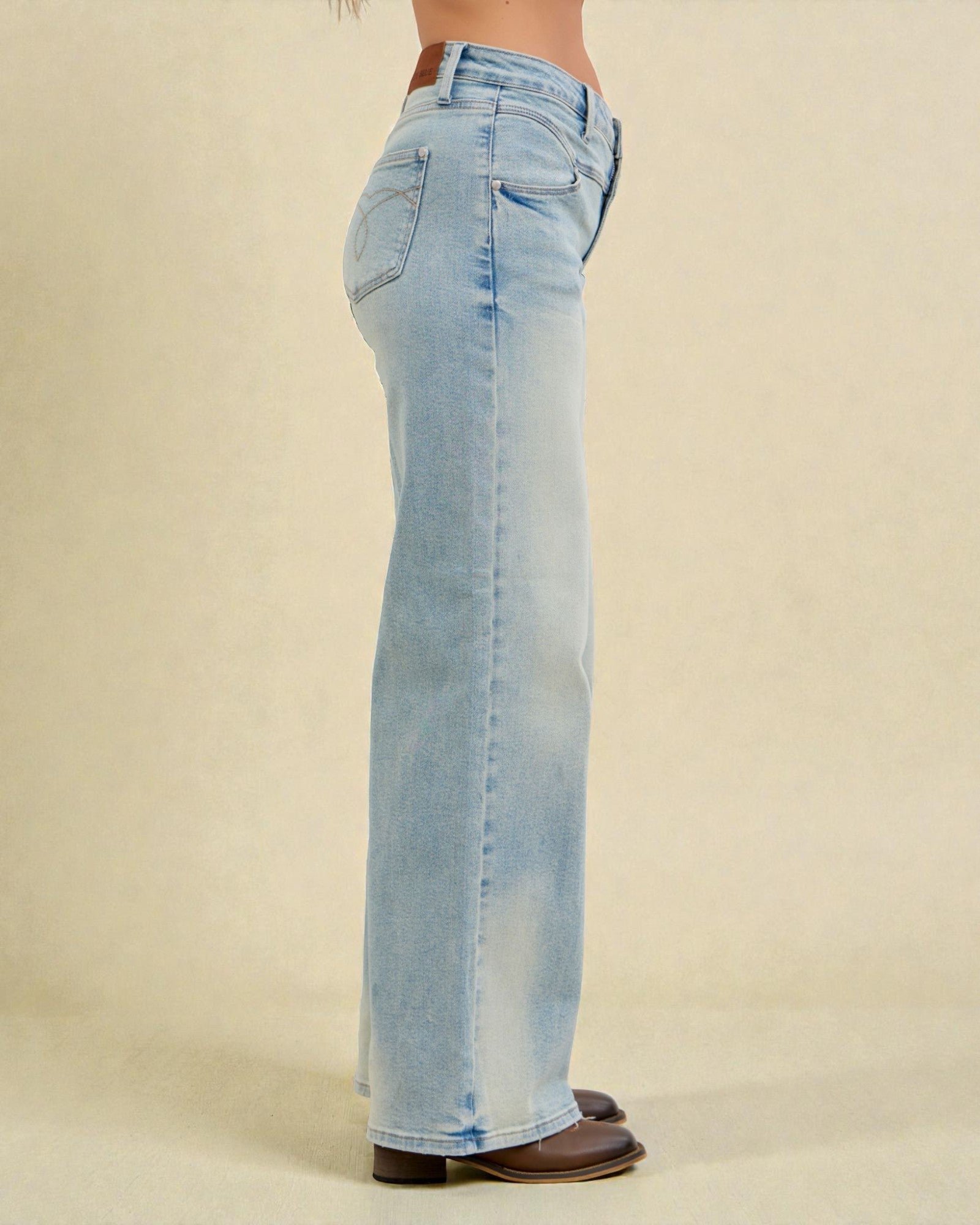 Light blue jeans worn by a person on a beige background