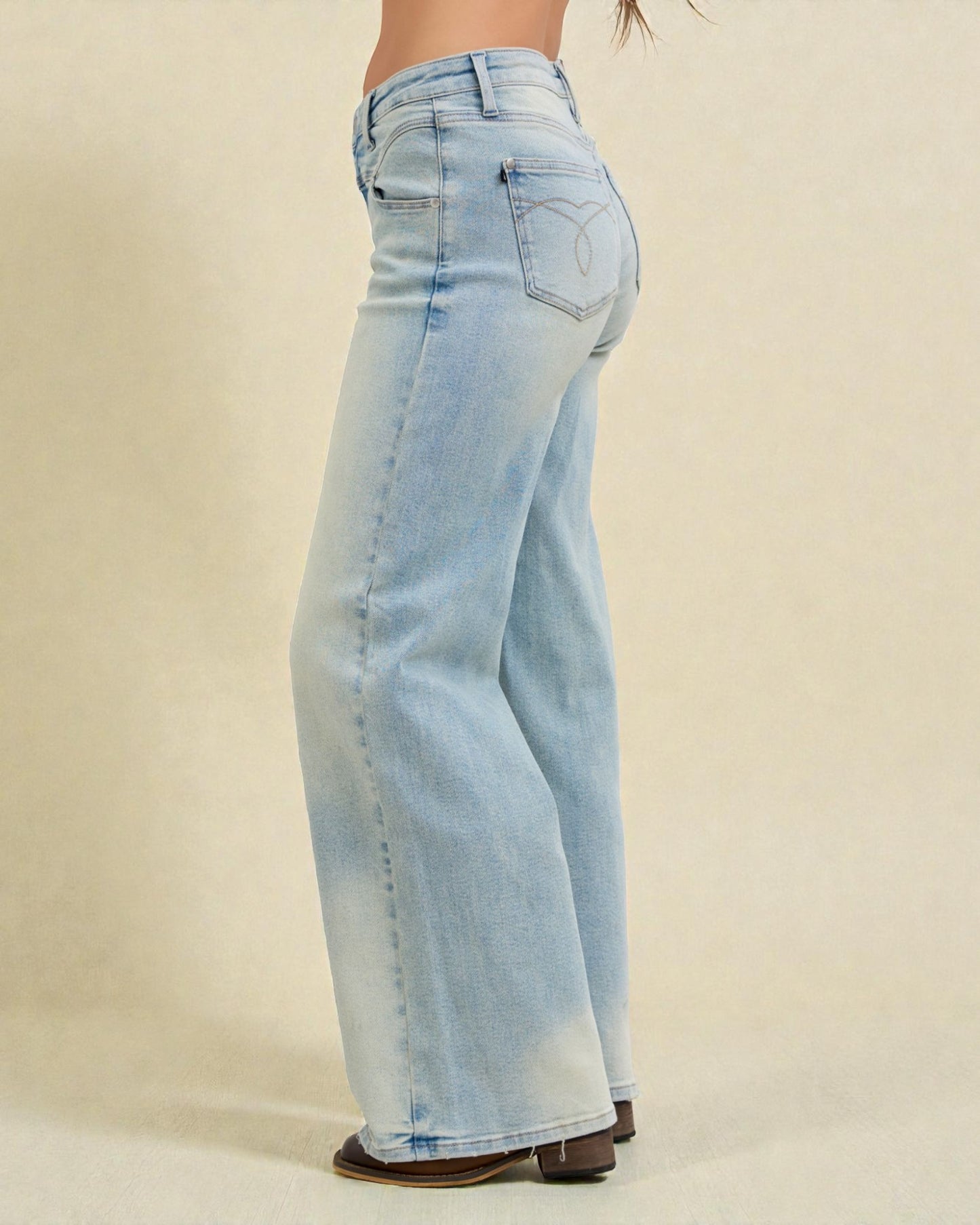 Light blue jeans worn by a person on a beige background