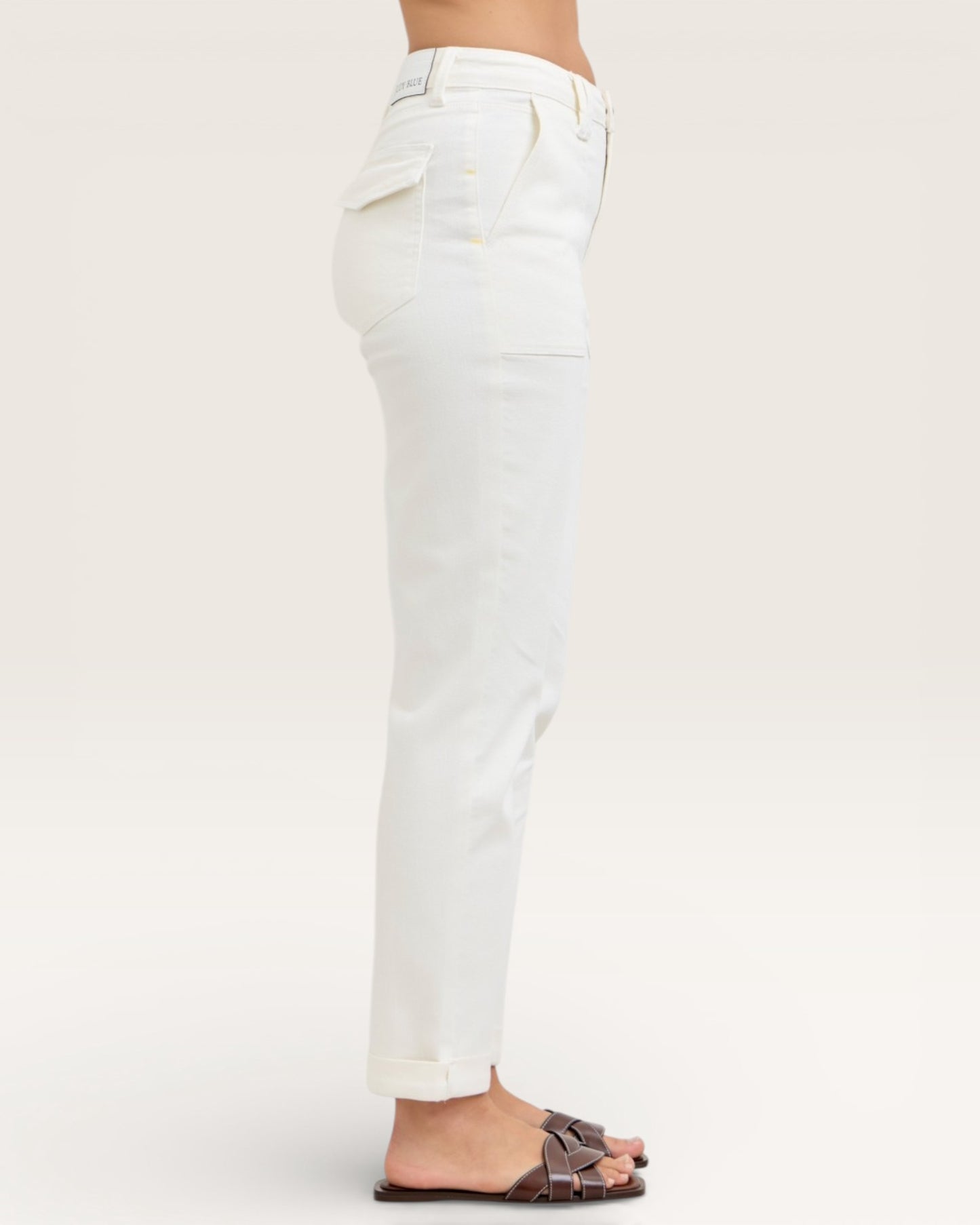 White jeans worn by a person on a plain background