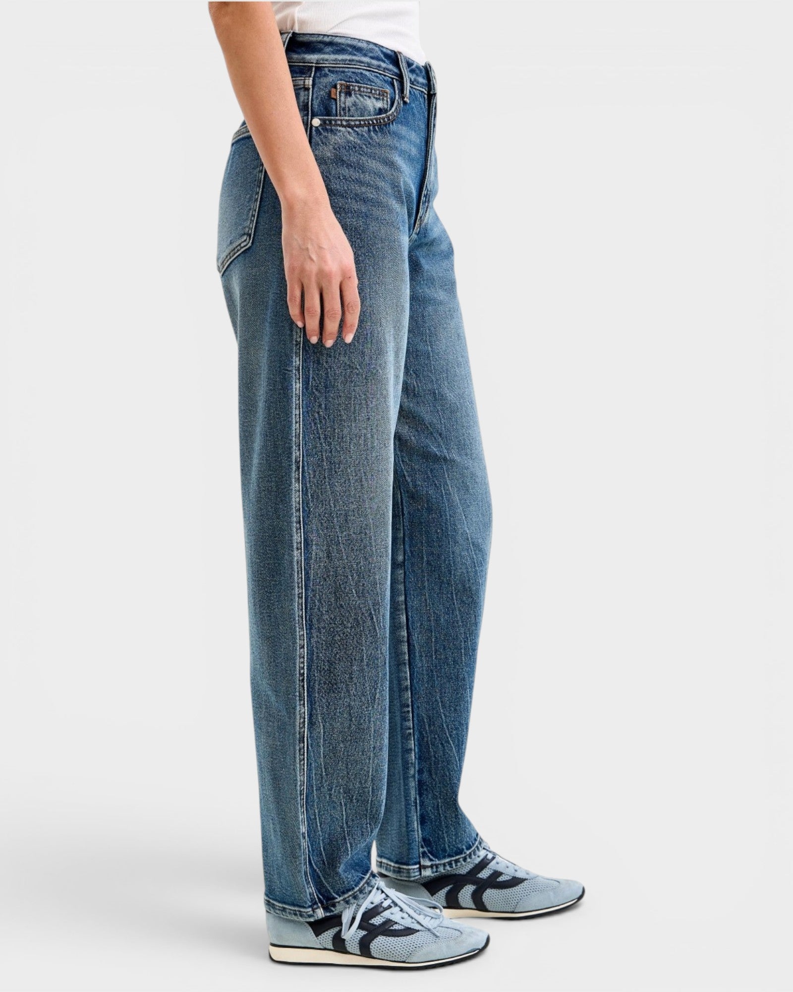 Person wearing blue jeans on a white background