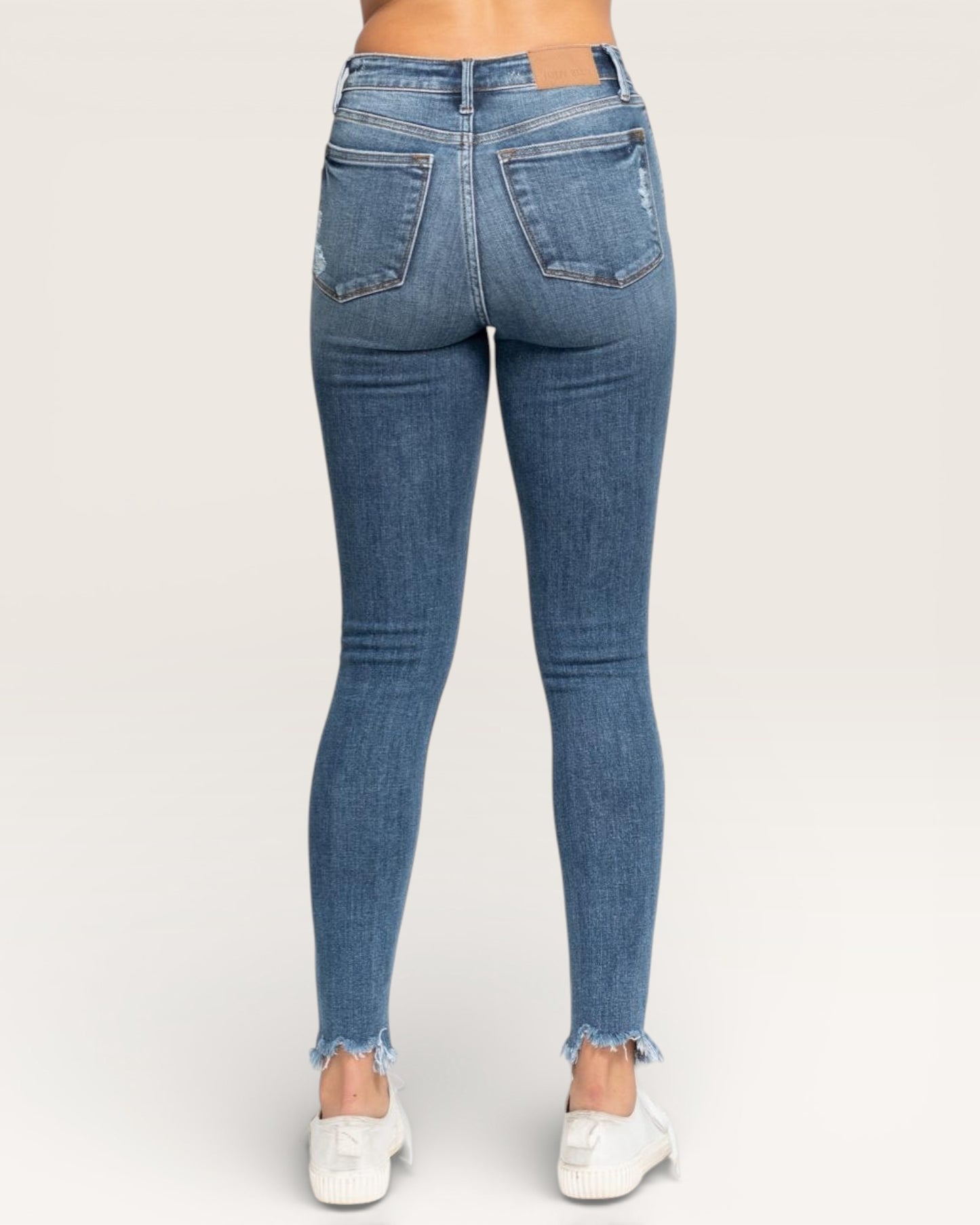 Blue jeans worn by a person on a white background