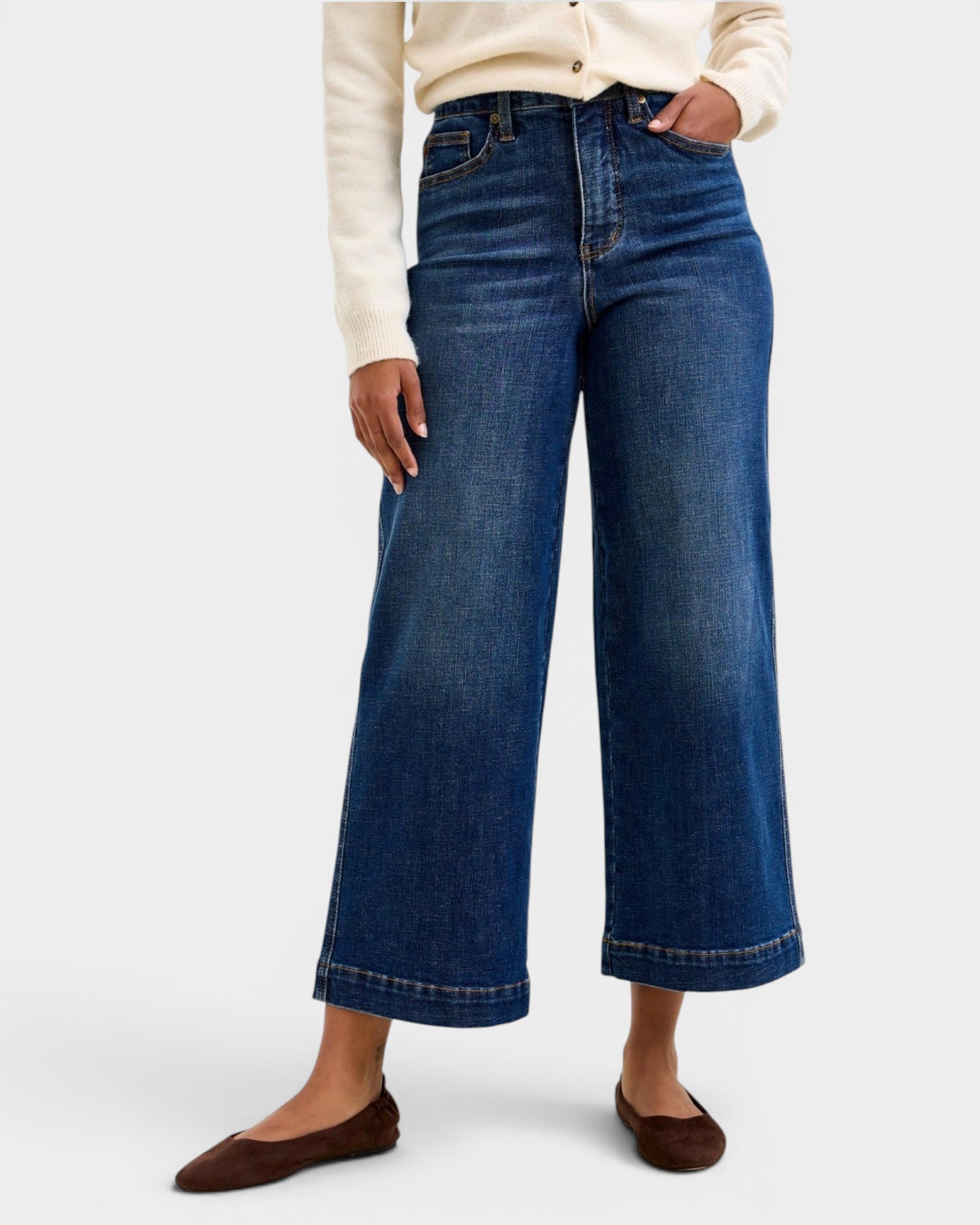 Person wearing blue wide-leg jeans on a white background