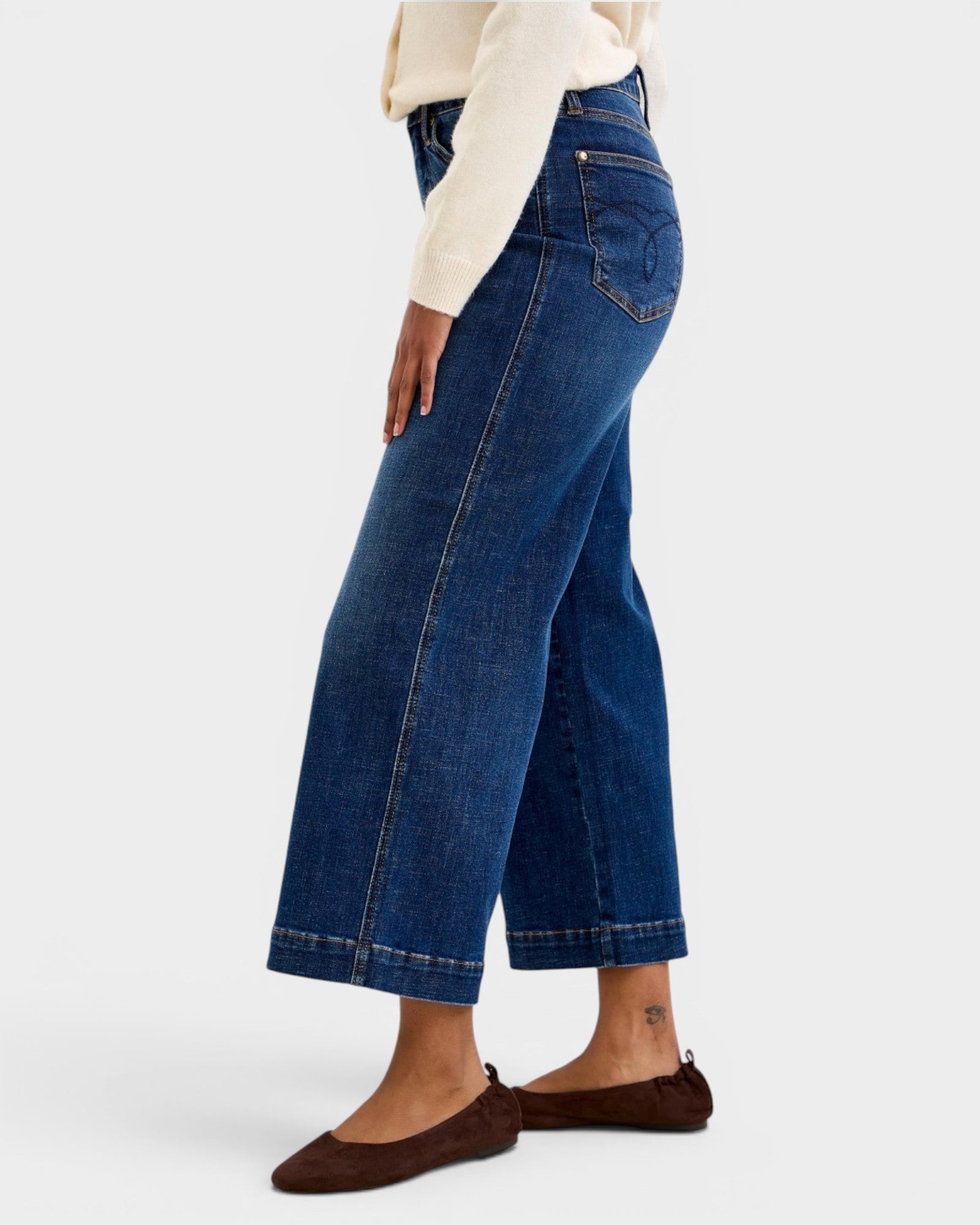 Person wearing blue jeans on a white background