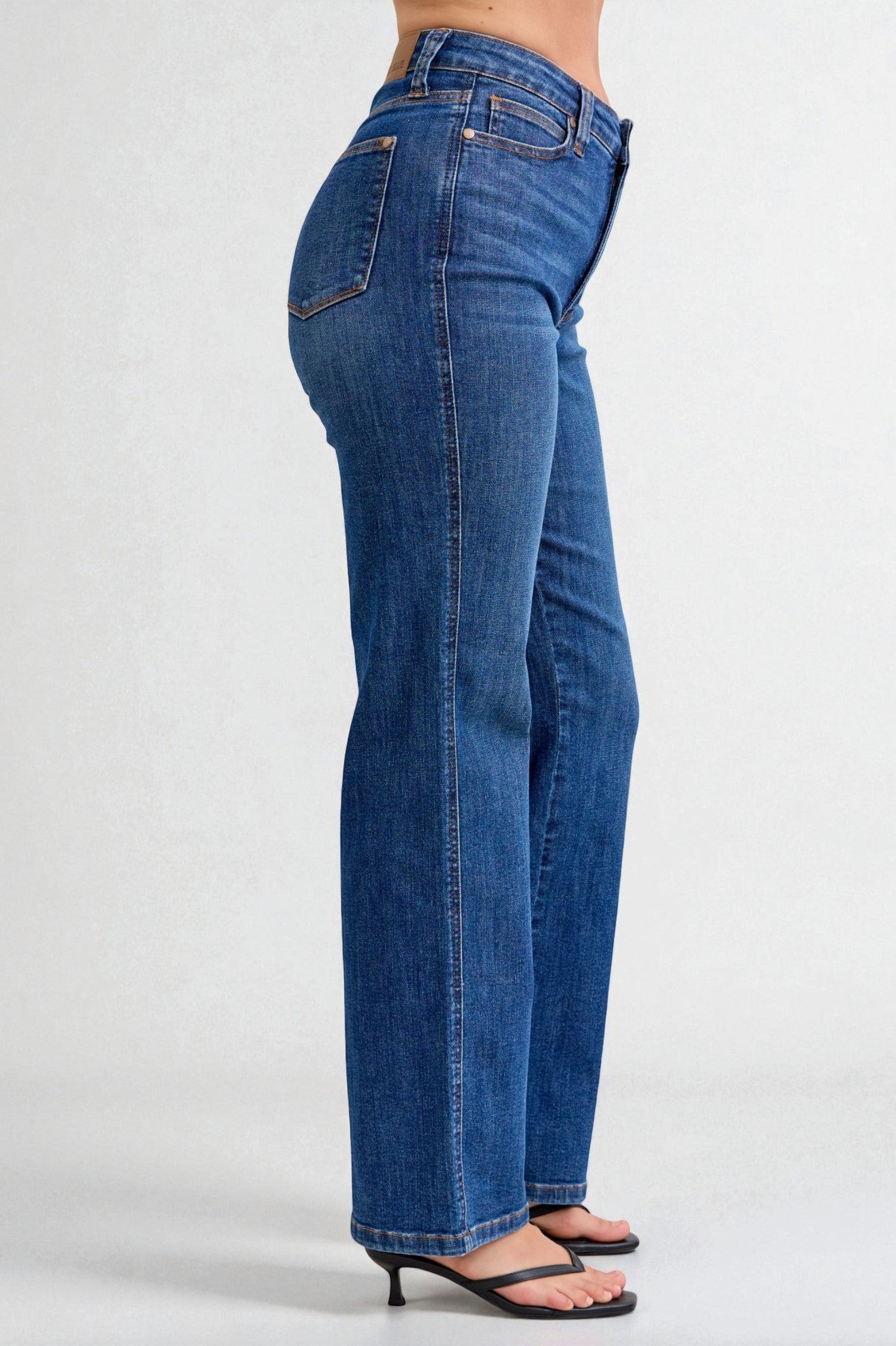 Blue jeans worn by a person on a white background
