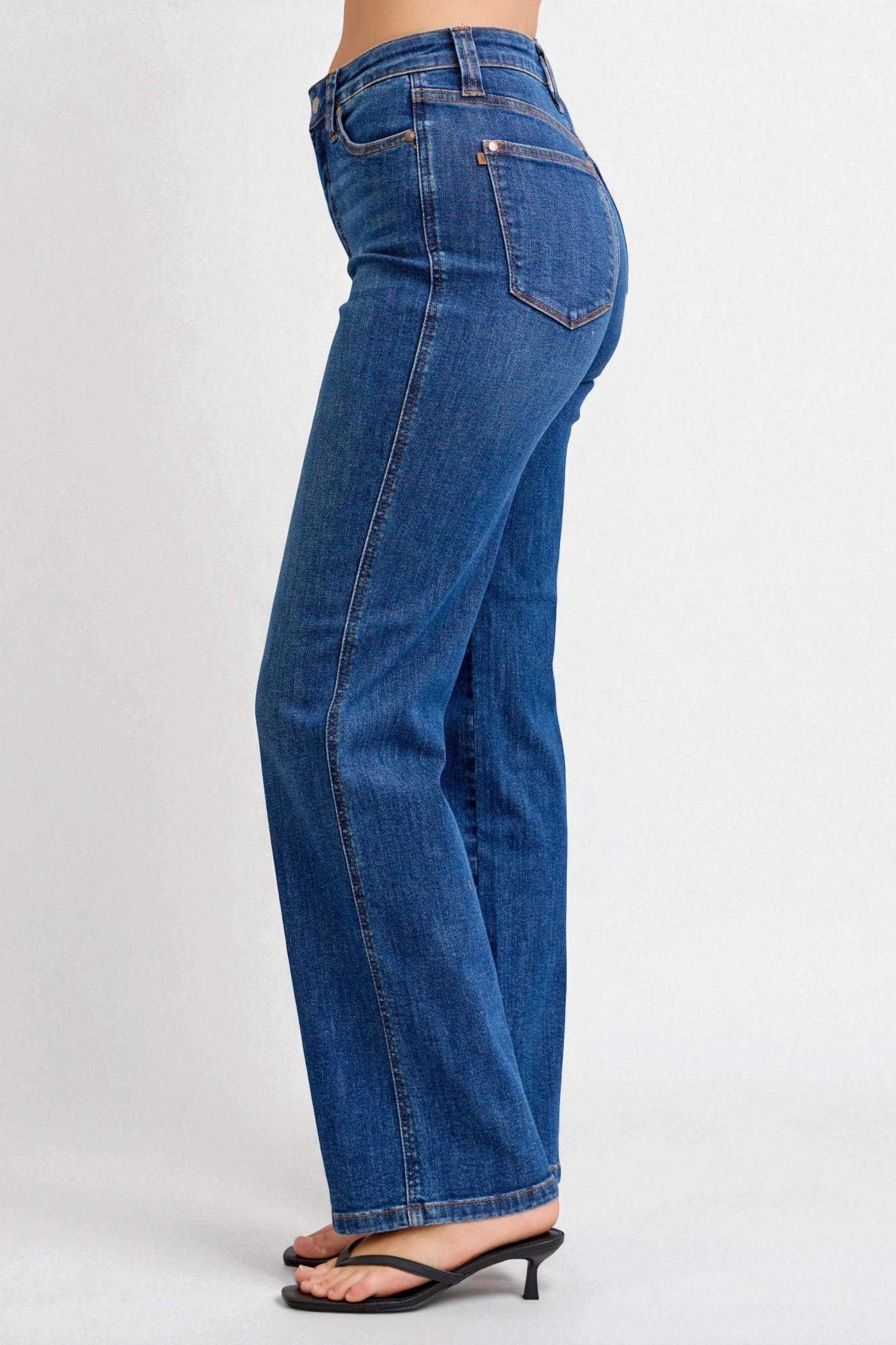 Blue jeans worn by a person on a white background