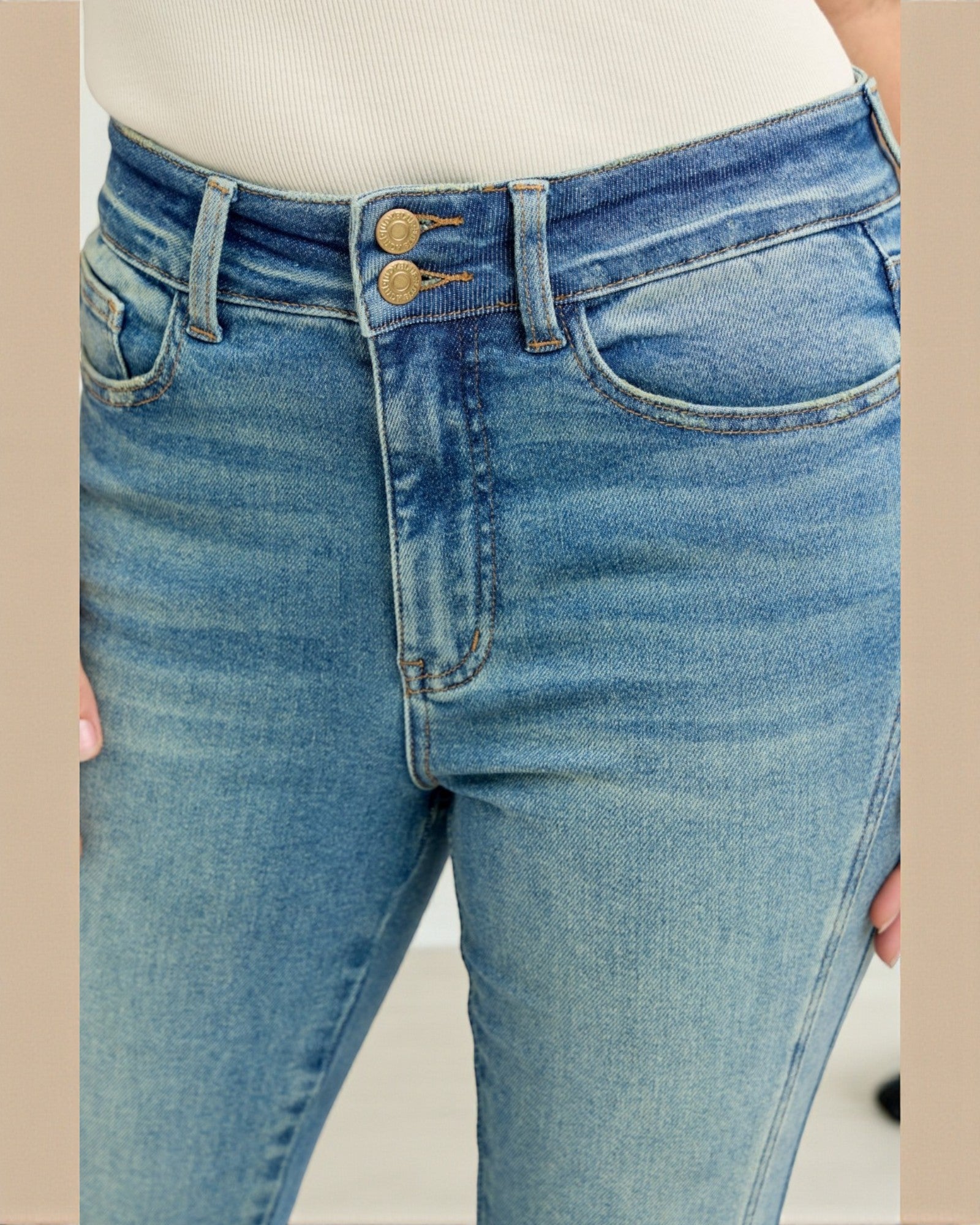 Close-up of blue jeans with a beige background