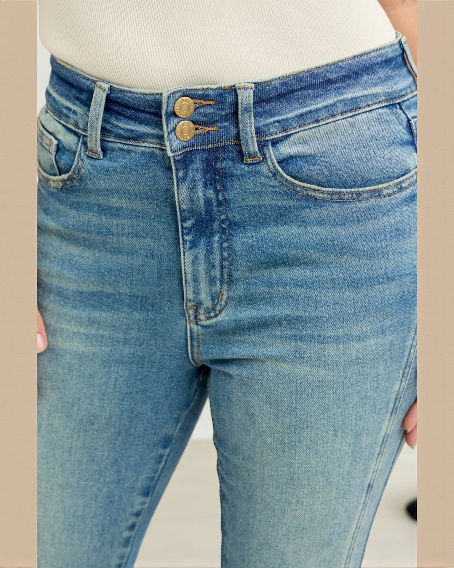 Close-up of blue jeans with a beige background