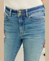 Close-up of blue jeans with a beige background