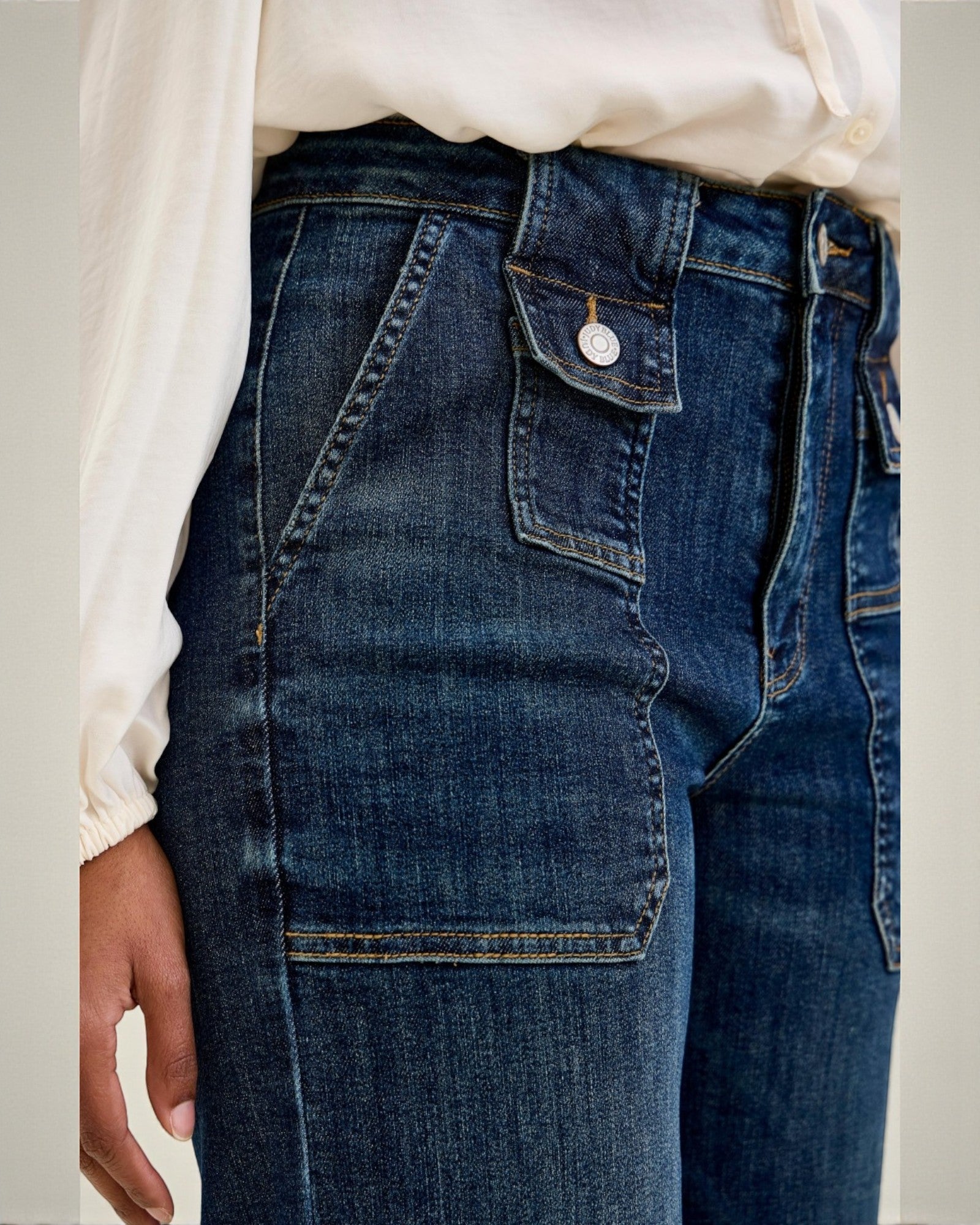 Close-up of blue jeans with a white shirt underneath
