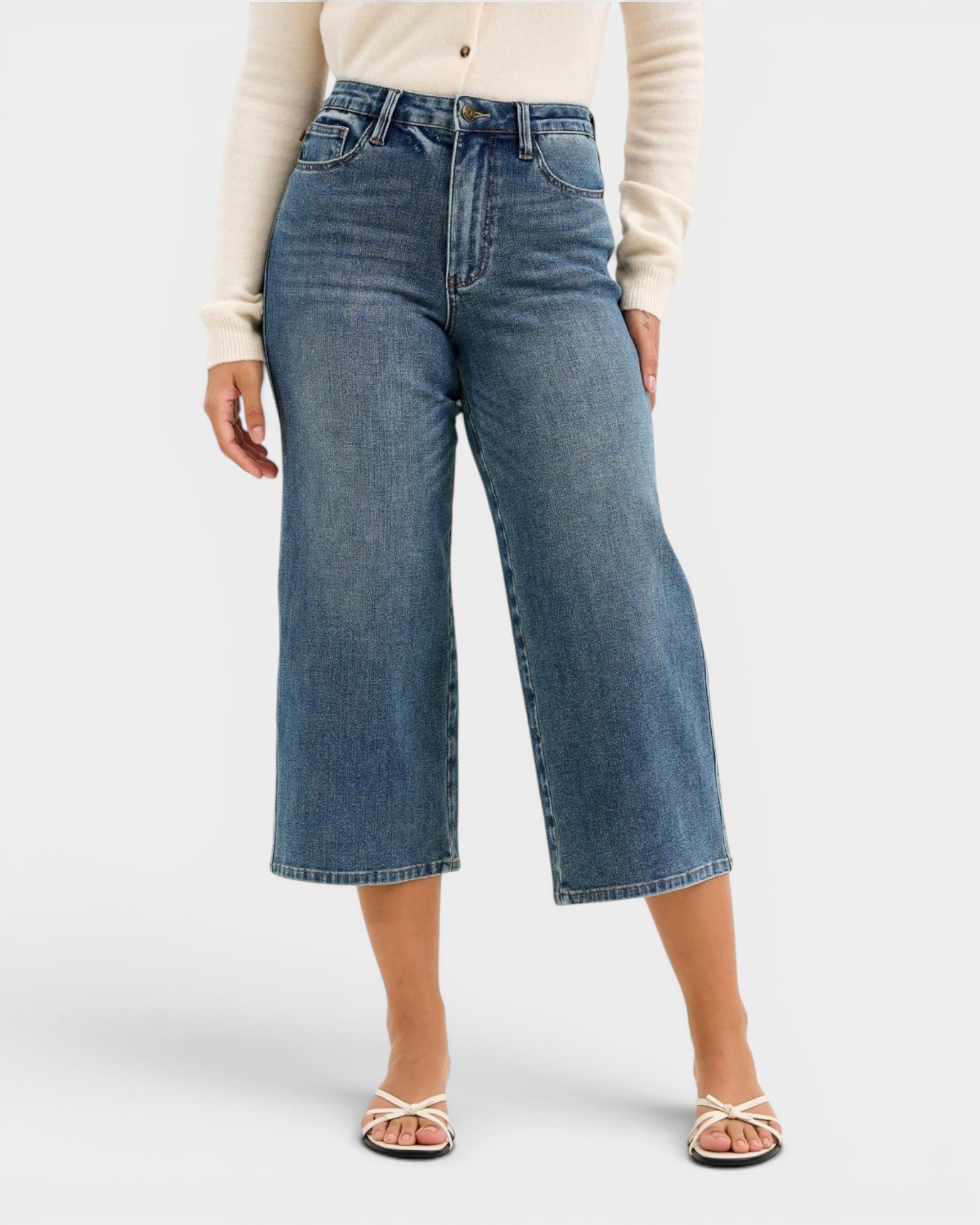 Person wearing blue jeans on a white background