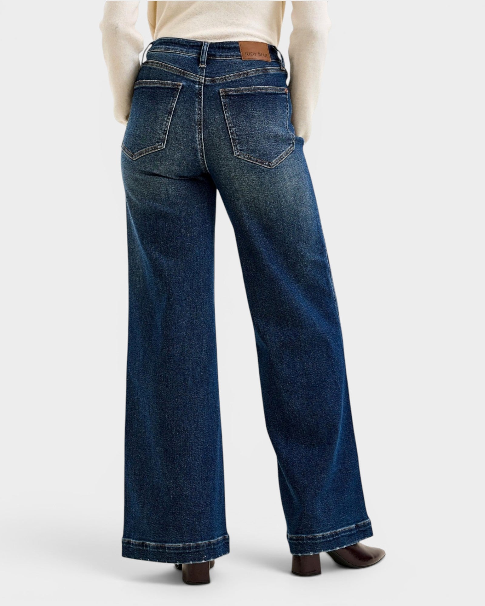 Blue jeans worn by a person on a white background