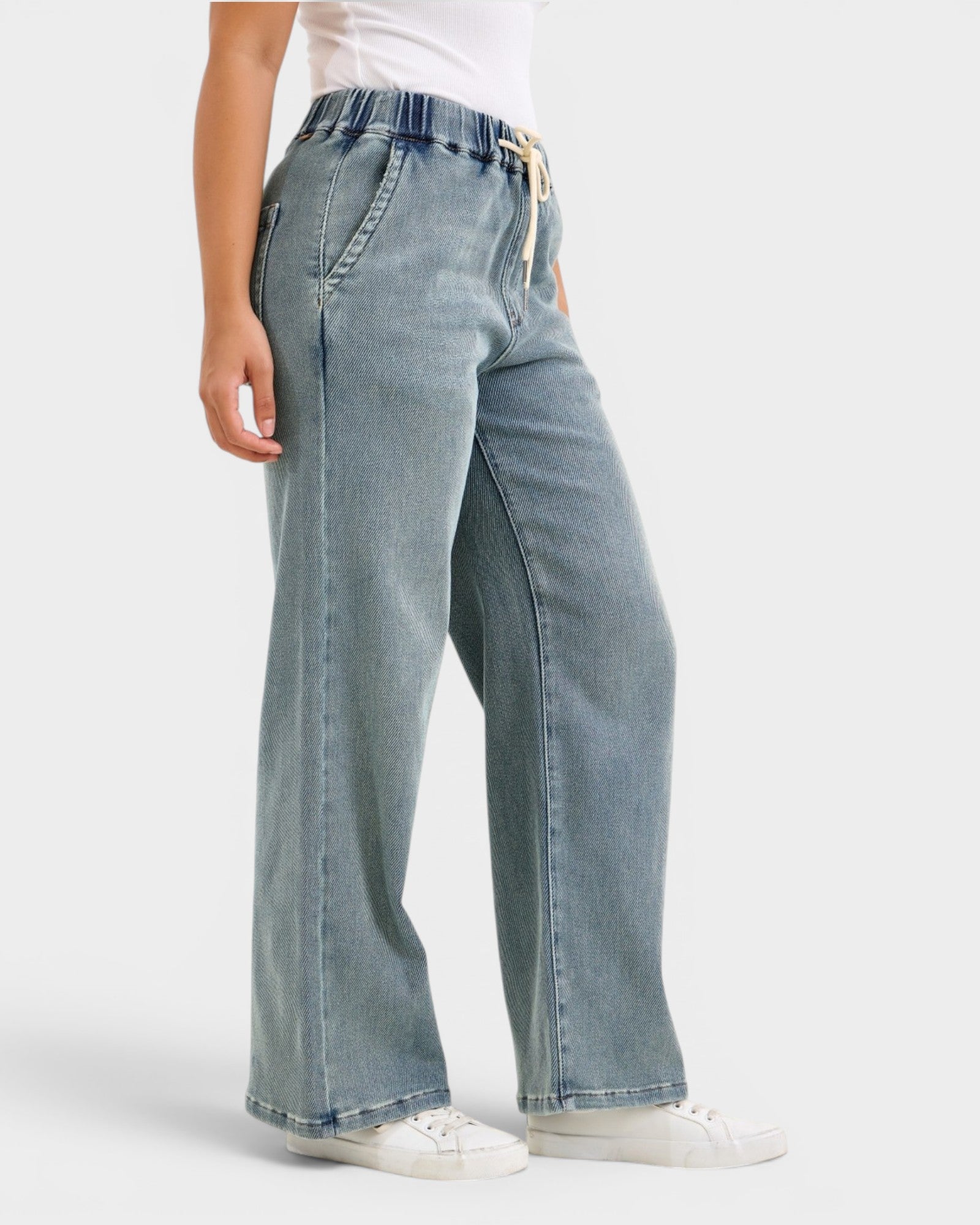 Light blue jeans worn by a person on a white background