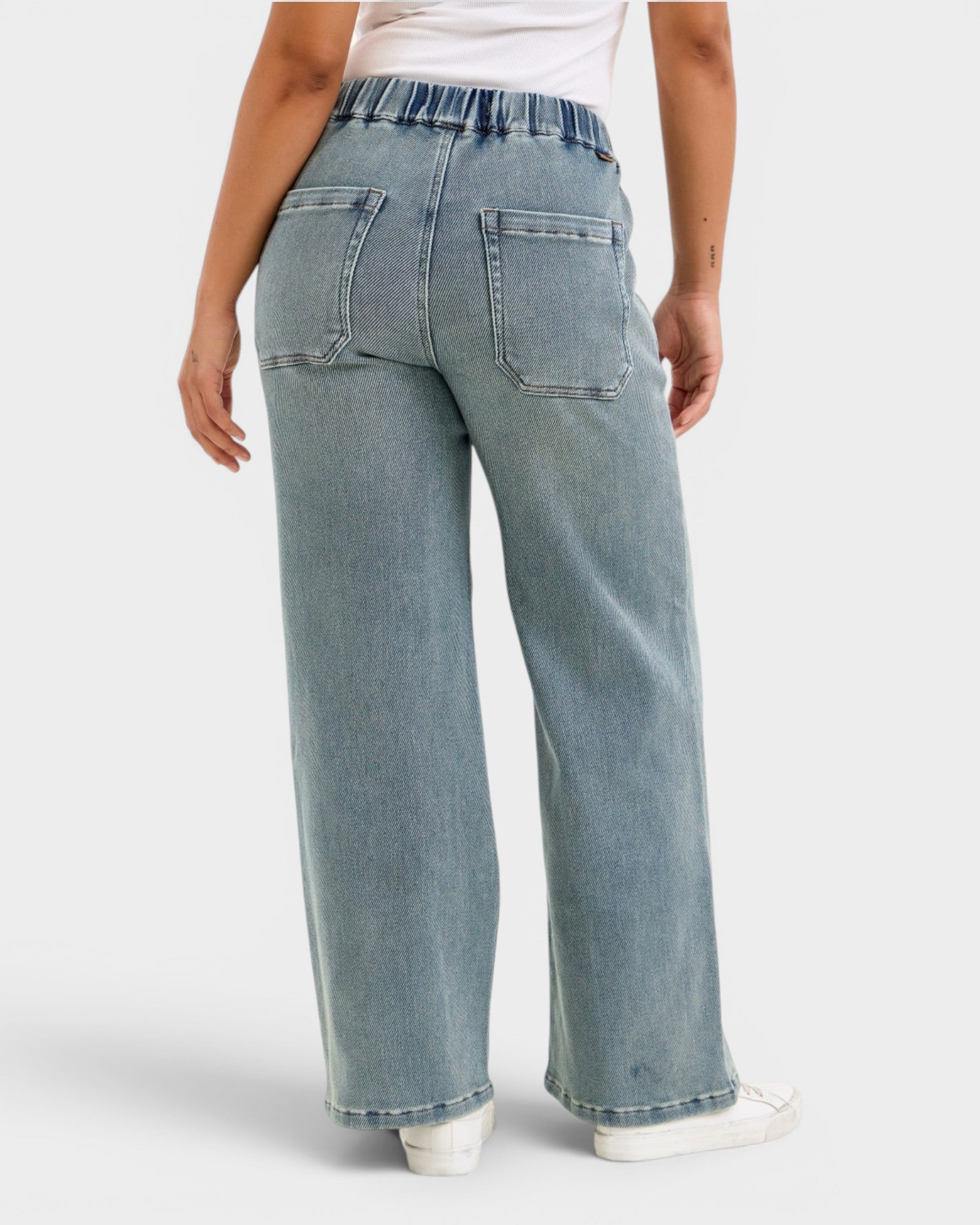 Light blue jeans worn by a person on a white background