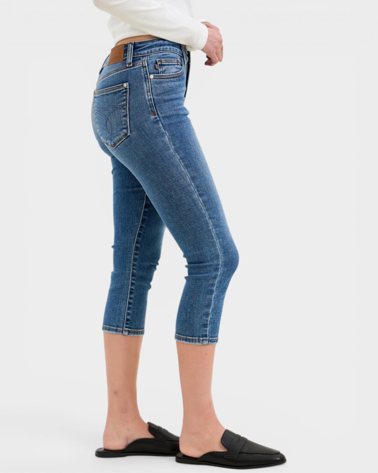 Person wearing blue jeans on a white background