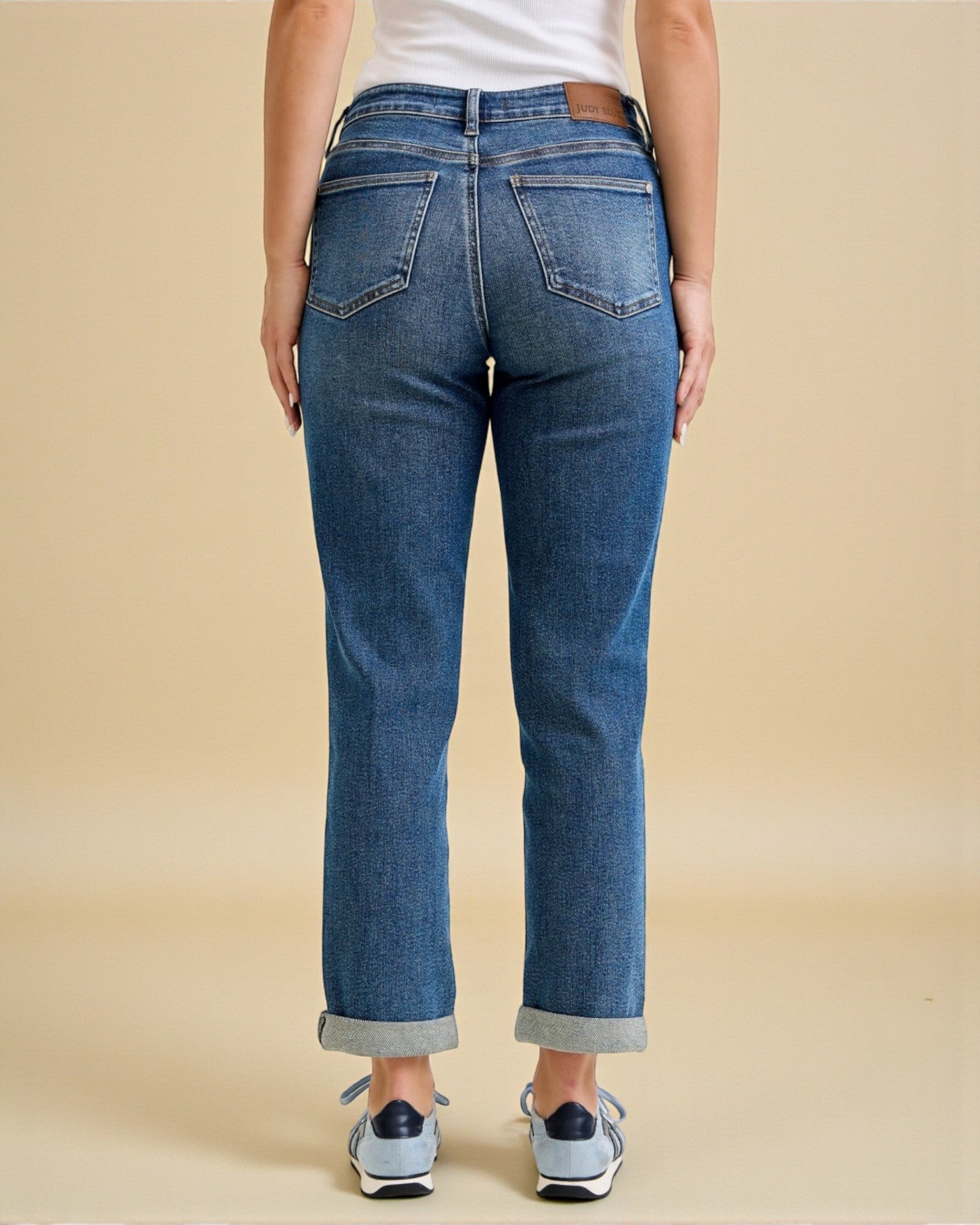 Person wearing blue jeans on a beige background