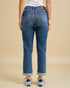 Person wearing blue jeans on a beige background
