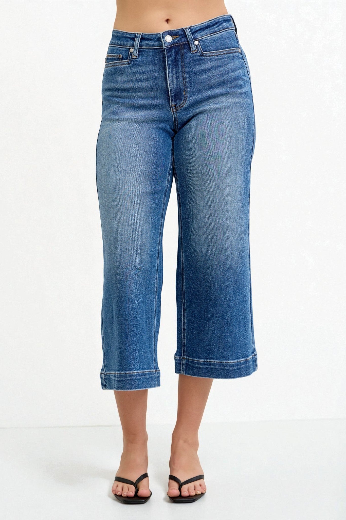 Blue jeans worn by a person on a white background