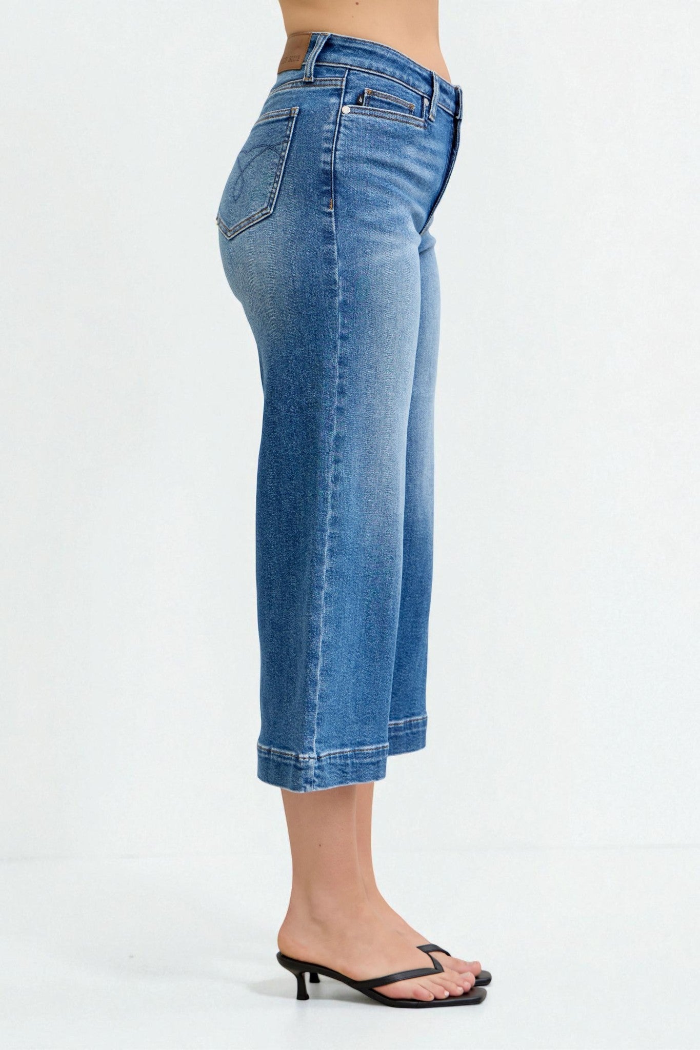 Blue jeans worn by a person on a white background