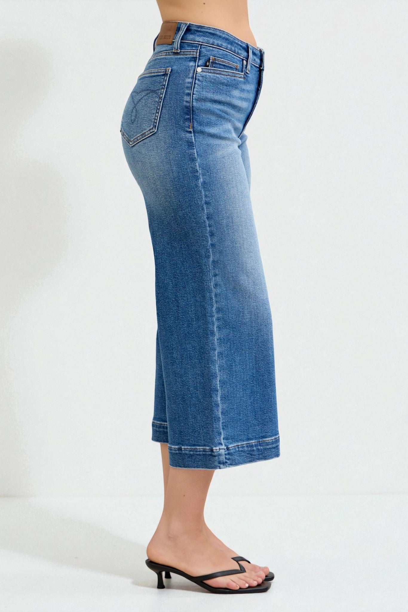 Blue jeans worn by a person on a white background