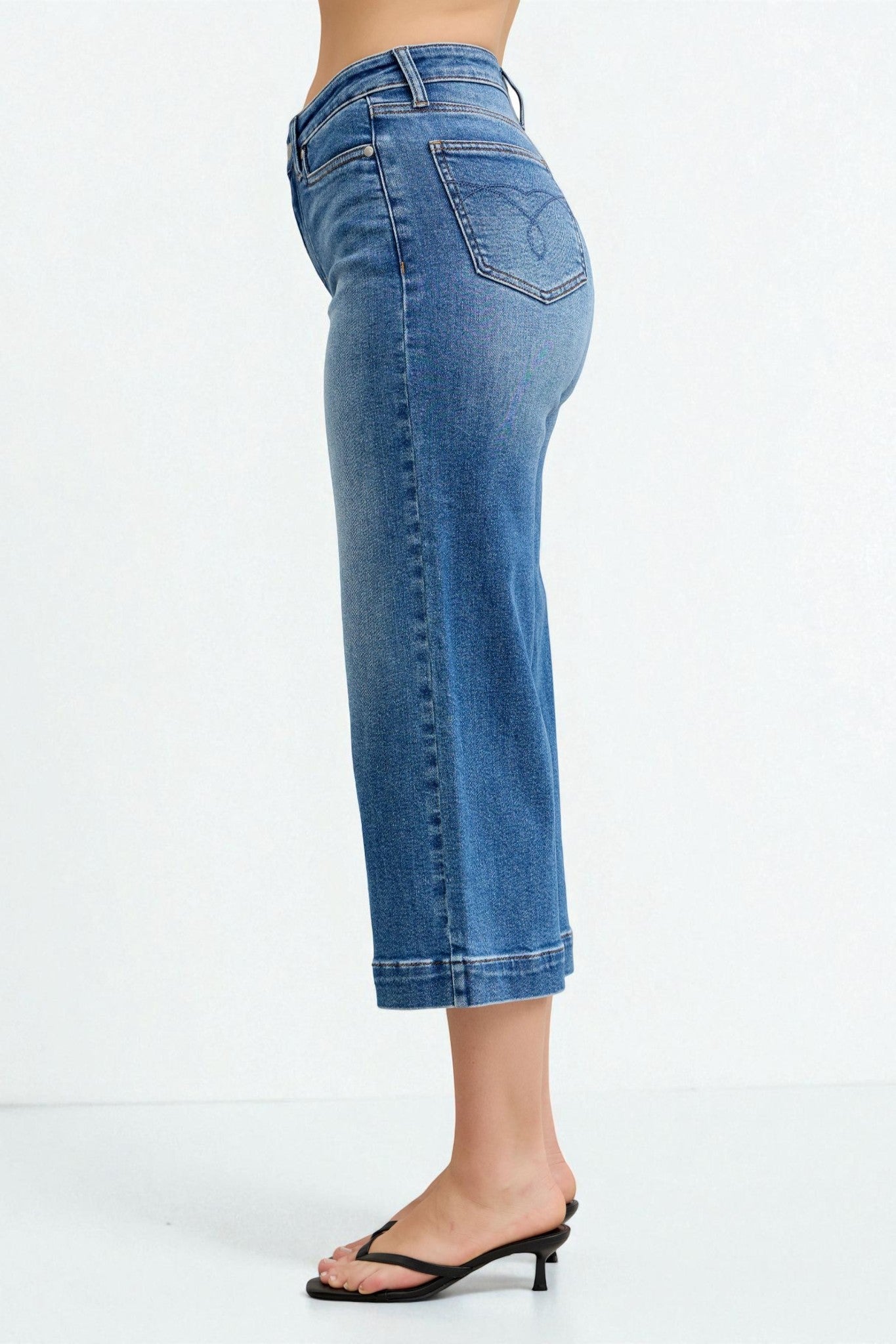 Blue jeans worn by a person on a white background