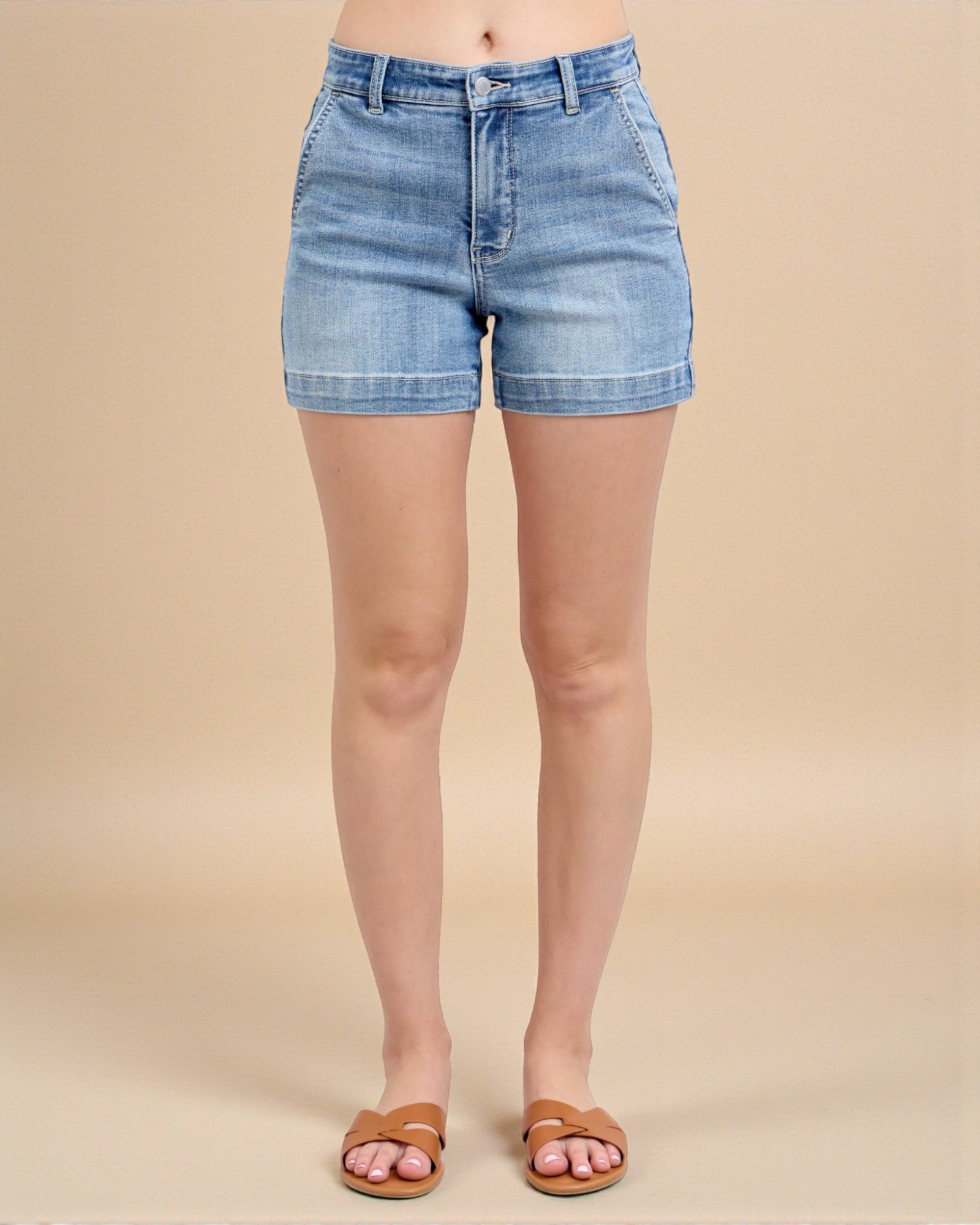 Denim shorts worn by a person on a beige background