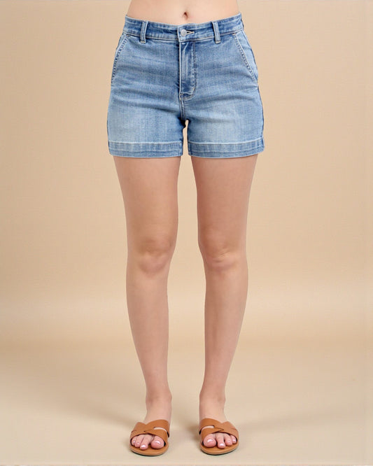 Denim shorts worn by a person on a beige background