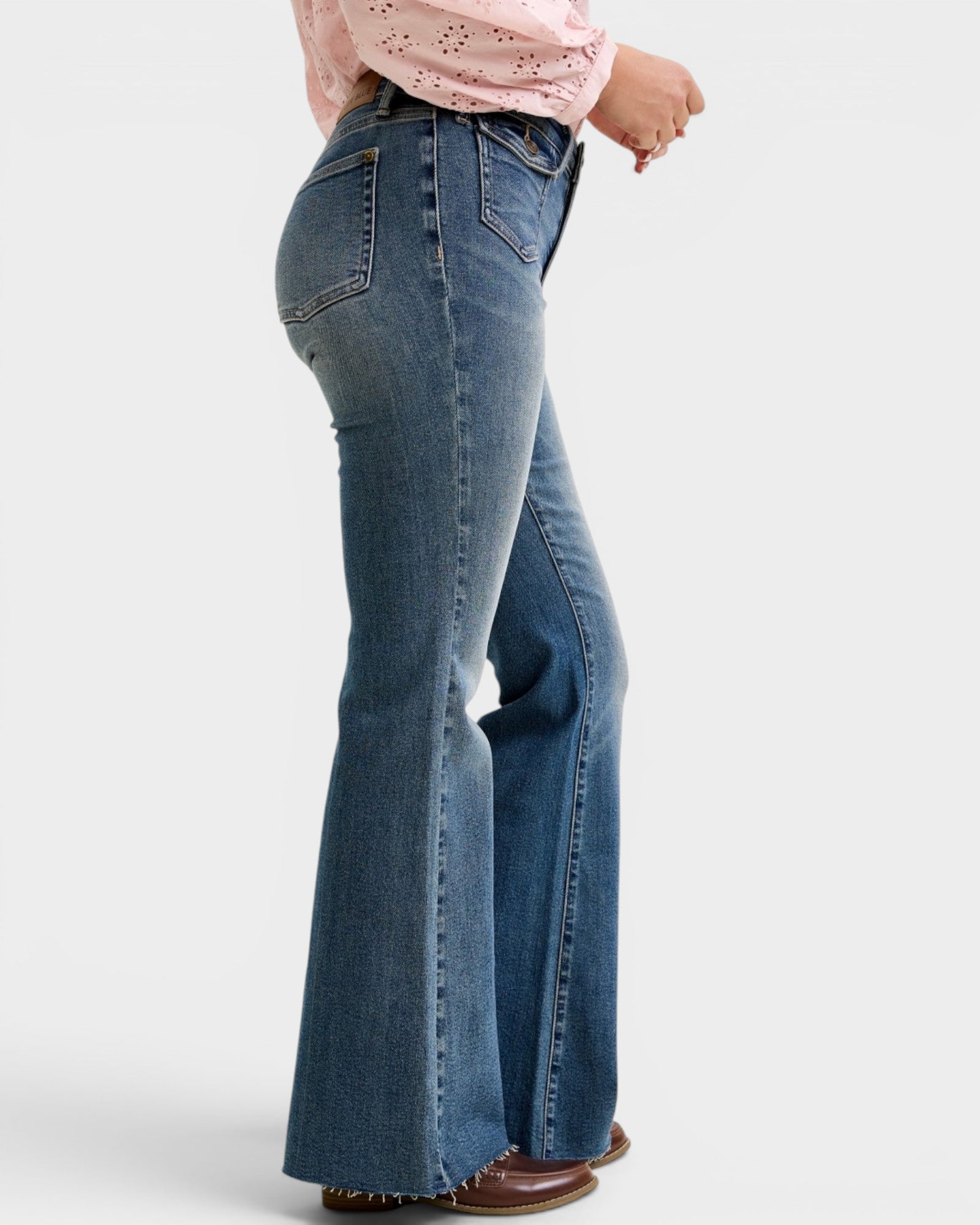 Flared jeans worn by a person on a white background