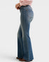 Person wearing blue flared jeans on a white background