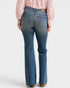 Person wearing blue jeans and a pink blouse on a white background