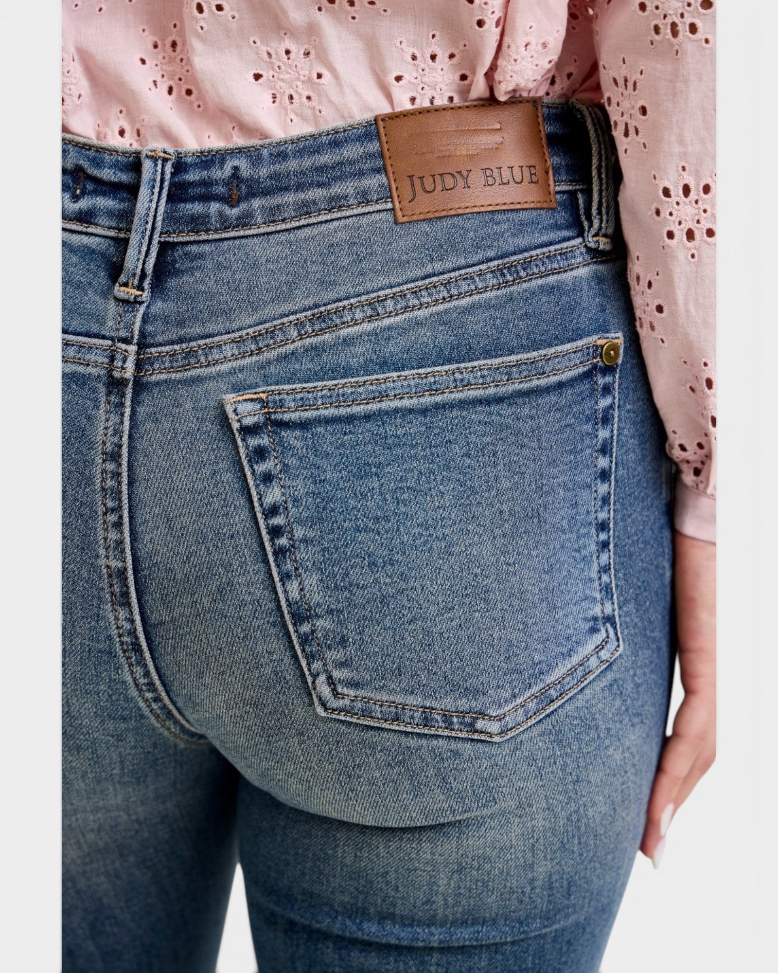 Blue jeans with a Judy Blue patch on a white background