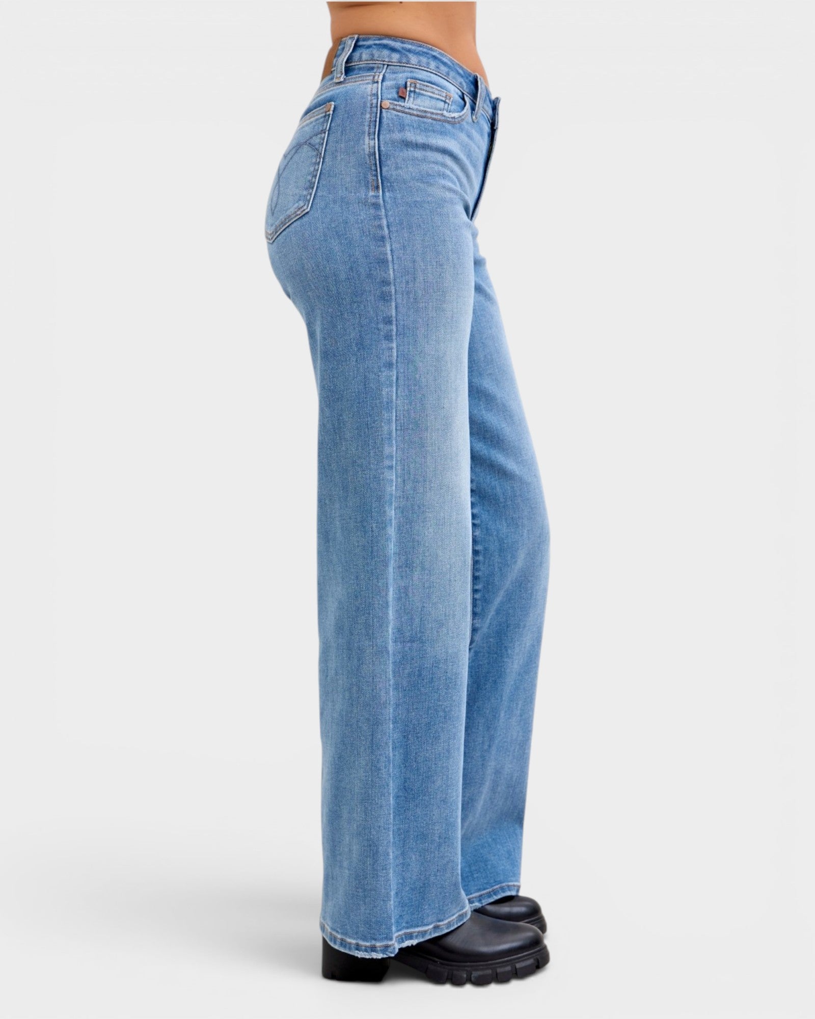 Blue jeans worn by a person on a white background