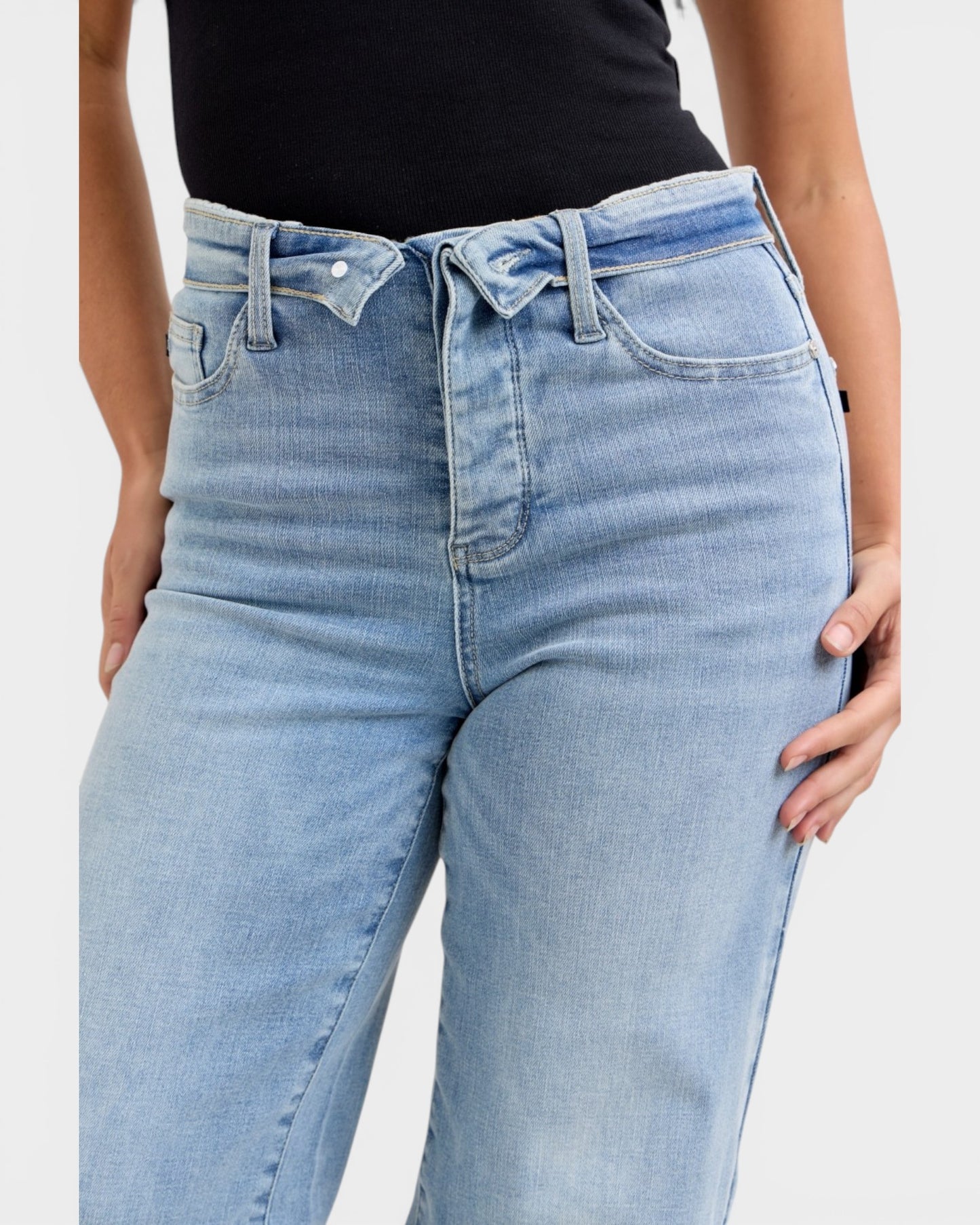 Light blue jeans worn by a person on a white background