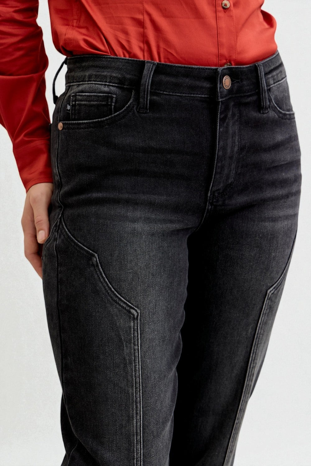 Person wearing black jeans and a red shirt on a white background