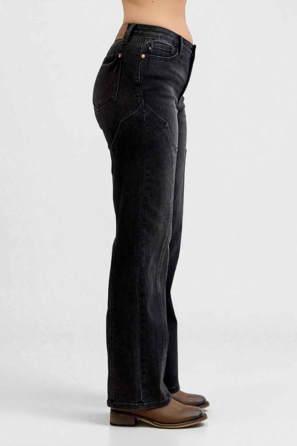 Black jeans worn by a person on a white background