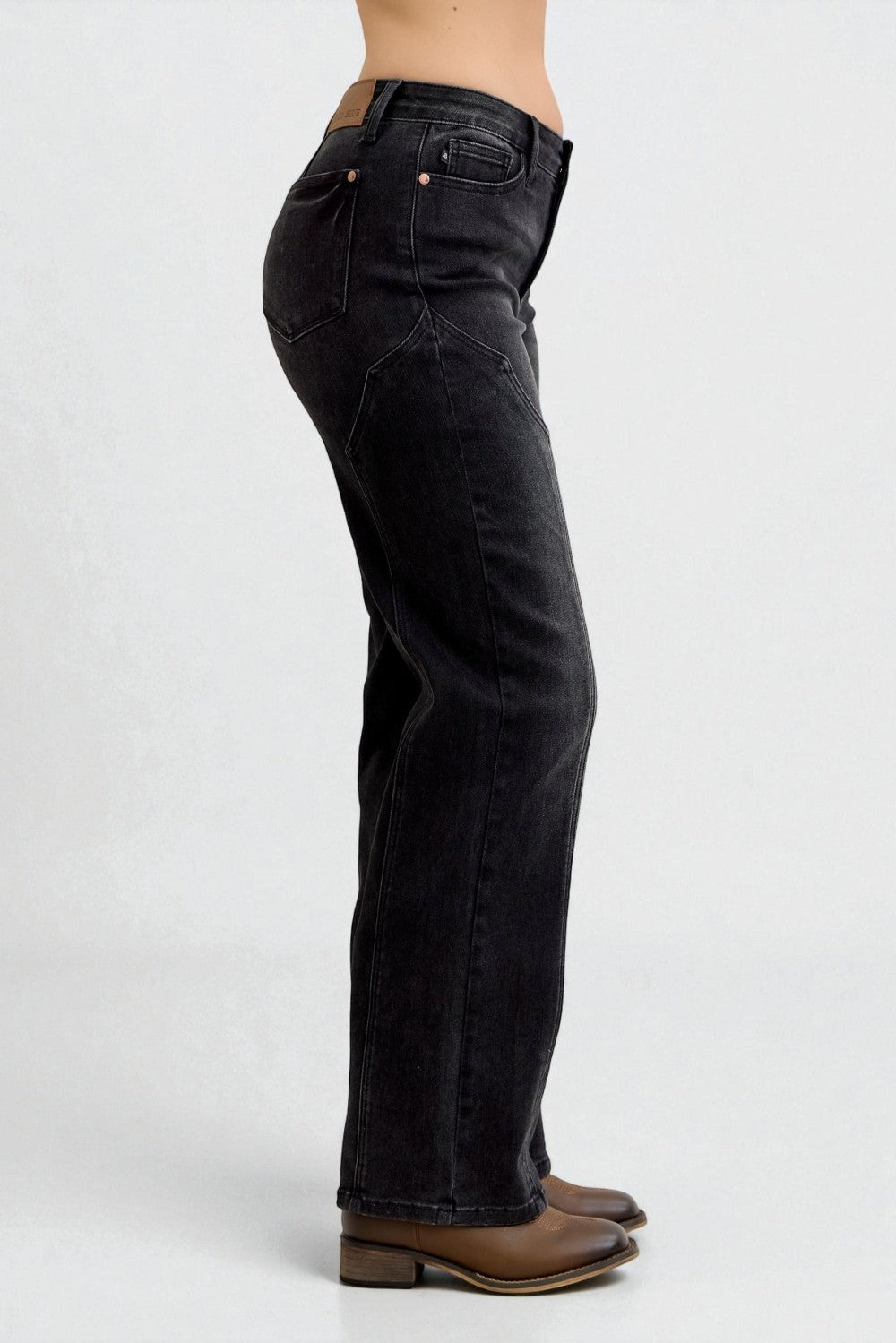 Black jeans worn by a person on a white background