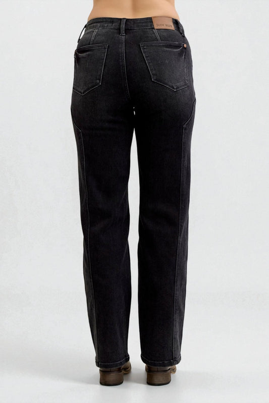 Black jeans worn by a person on a white background